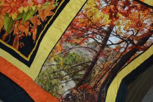 a quilt panel that shows trees and fall colors
