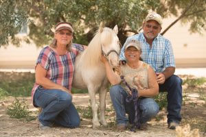 Sara Millard is pictured with her mom, Vicky, and father, John, and horse, Tazz