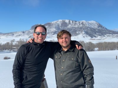 Dr. Richard Gitter and his son, Ben, stand in a snowy field in this photo.