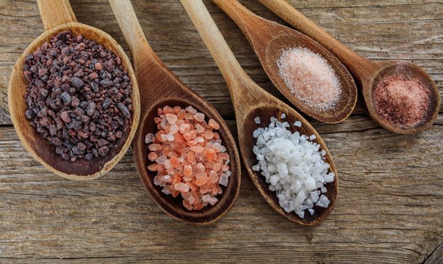 This photo shows cooking spoons with different colors of salt crystals to help explain what is salt.